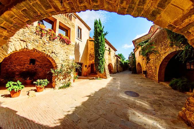 Plaza Mayor de Monells, pueblo medieval del Empordà en Girona, con calles empedradas y ambiente tranquilo ideal para pasear con perro